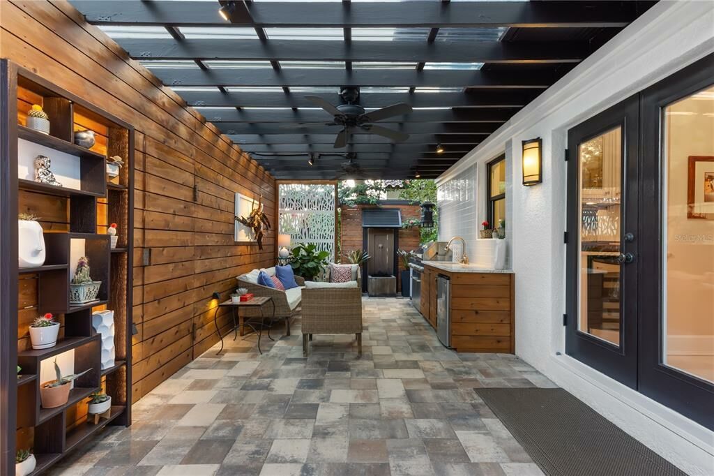 Beautiful luxury covered patio with dark woods, black accents and stone flooring